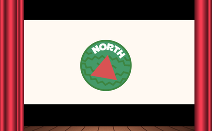 A watermelon with the word 'North' and a red triangle in the middle, displayed on a theatre screen framed by curtains.